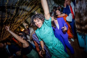 Invitada con vestido turquesa saltando en una fiesta