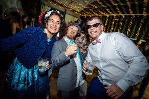 Tres amigos divertidos pasándoselo en grande en una boda