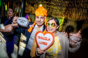 Dos amigos con pelucas naranjas y carteles divertidos Tequila Lover en una boda